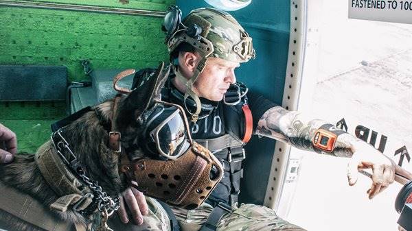 Robbie Hill of Mission Volant wearing his MultiCam EXFIL Ballistic helmet in a helicopter before he jumps with a working dog.