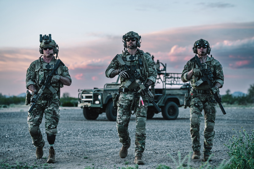 3 US soldiers wearing Team Wendy EXFIL Ballistic helmets walking in rough outdoor terrain during sunset