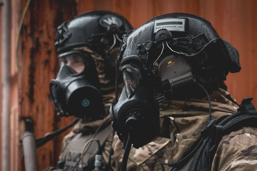 2 soldiers in CBR attire including a Team Wendy ballistic helmet and Avon Protection respirator