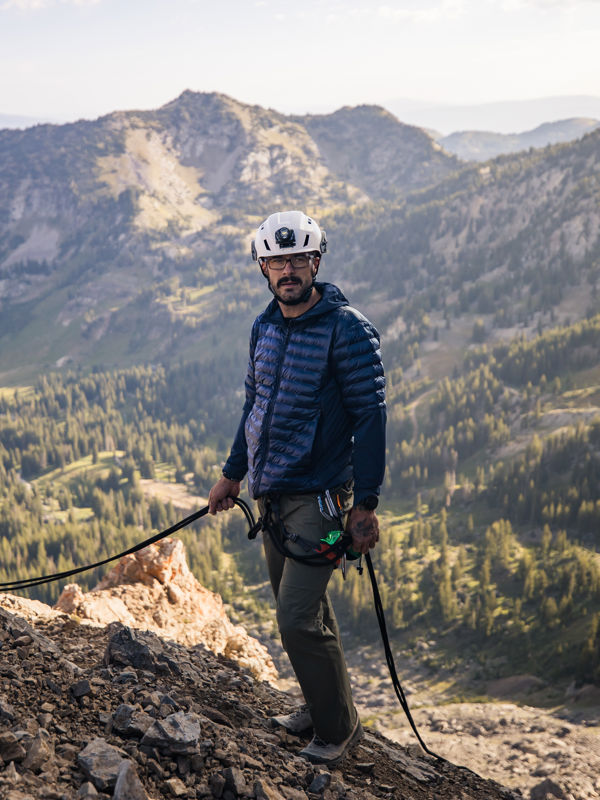 Uomo con un casco bianco in testa che tiene in mano una corda