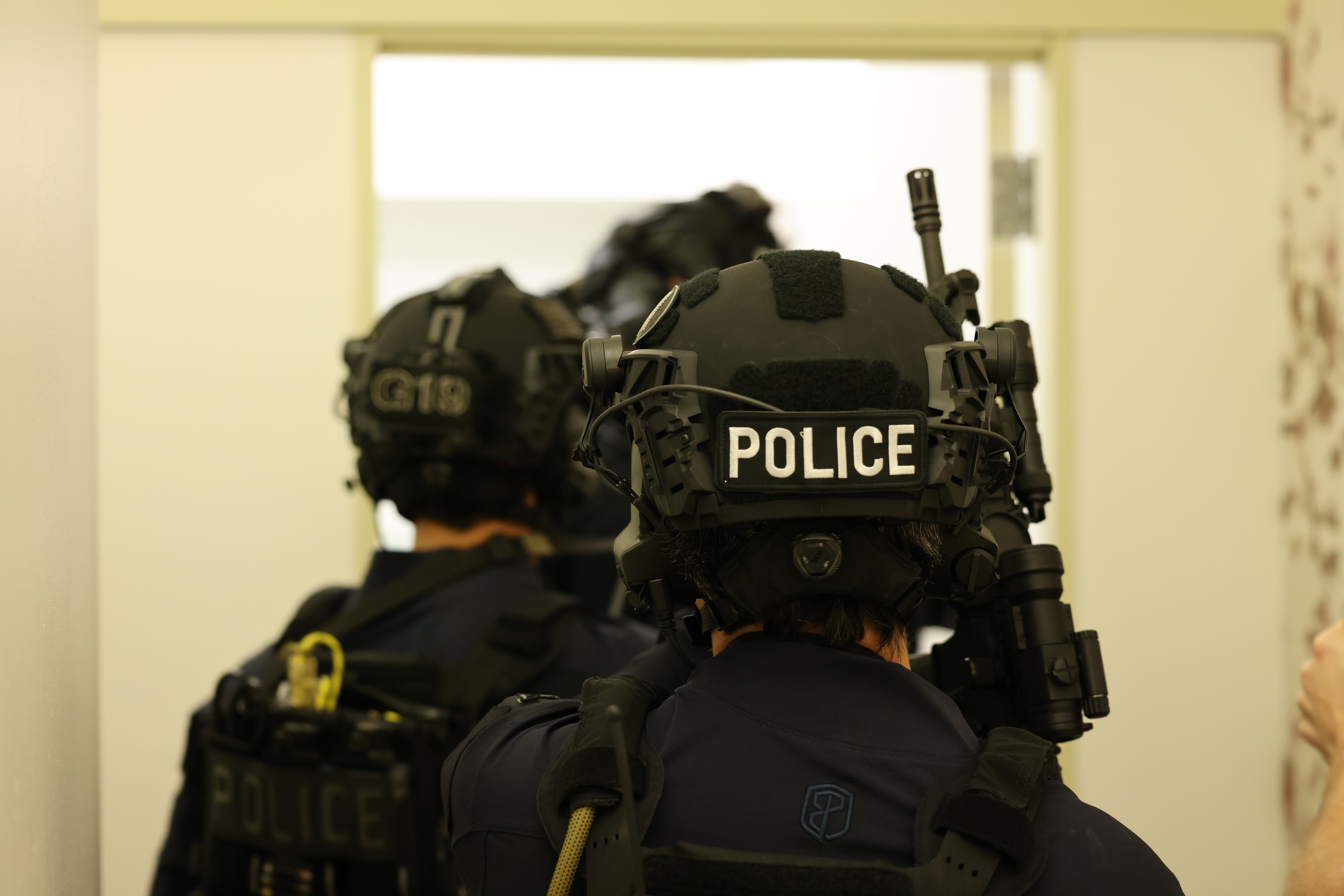 Three SWAT team members wearing tactical gear including a black Team Wendy RIFLETECH helmet