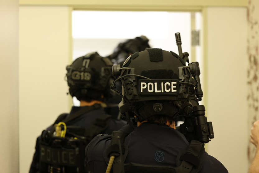 Three SWAT team members wearing tactical gear including a black Team Wendy RIFLETECH helmet
