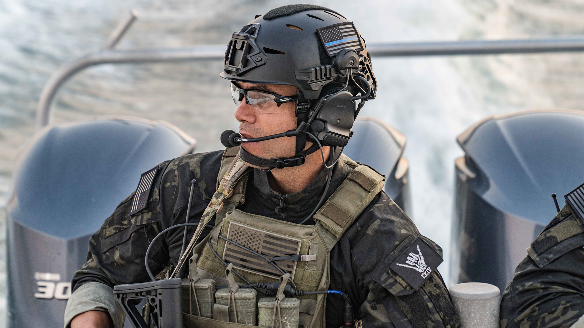 Man in black helmet and green vest wearing camo