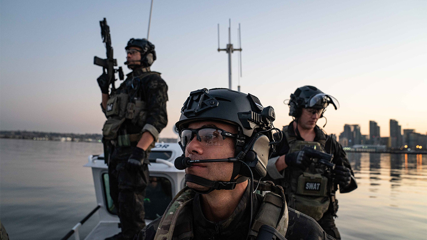 3 men in swat uniform on a boat and holding guns