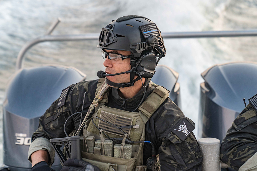 Man in camo and vest wearing a helmet