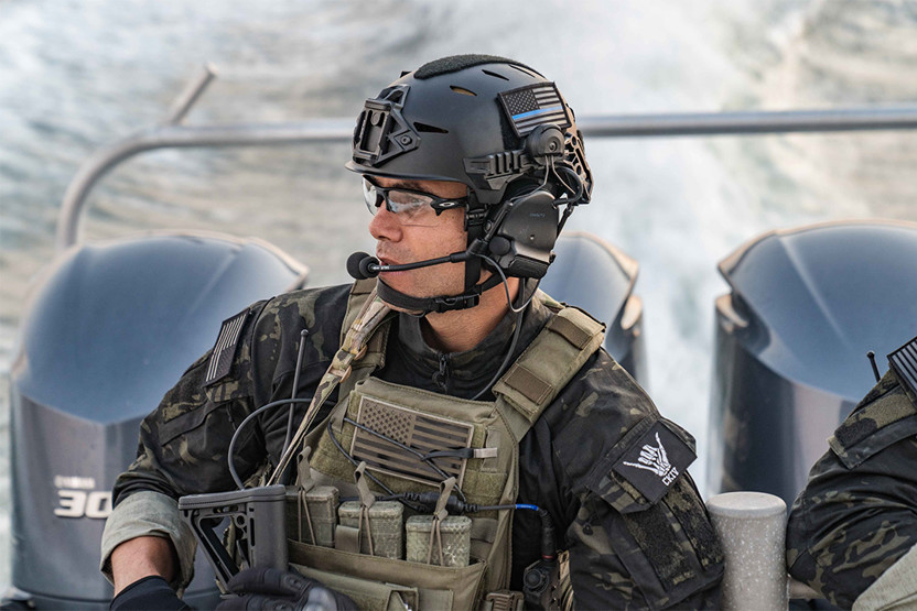 Man in camo and vest wearing a helmet