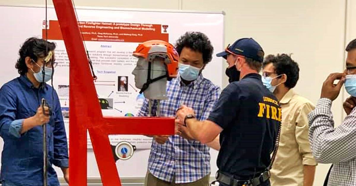 People wearing masks looking at a display helmet
