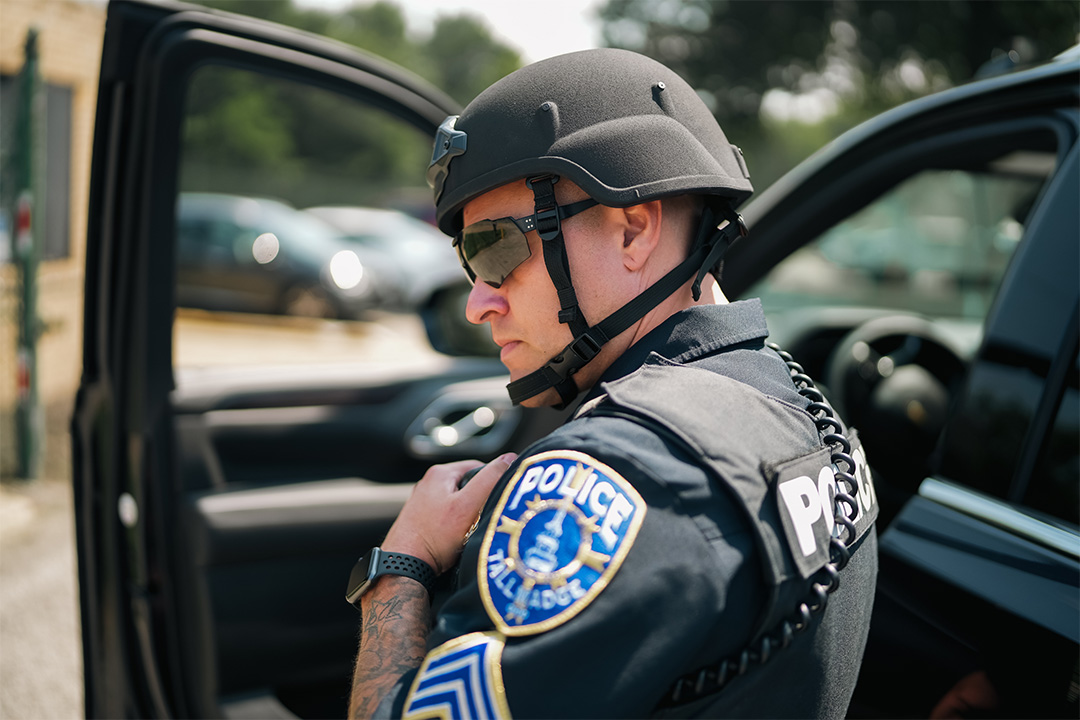 Policeman with helmet on talking into radio