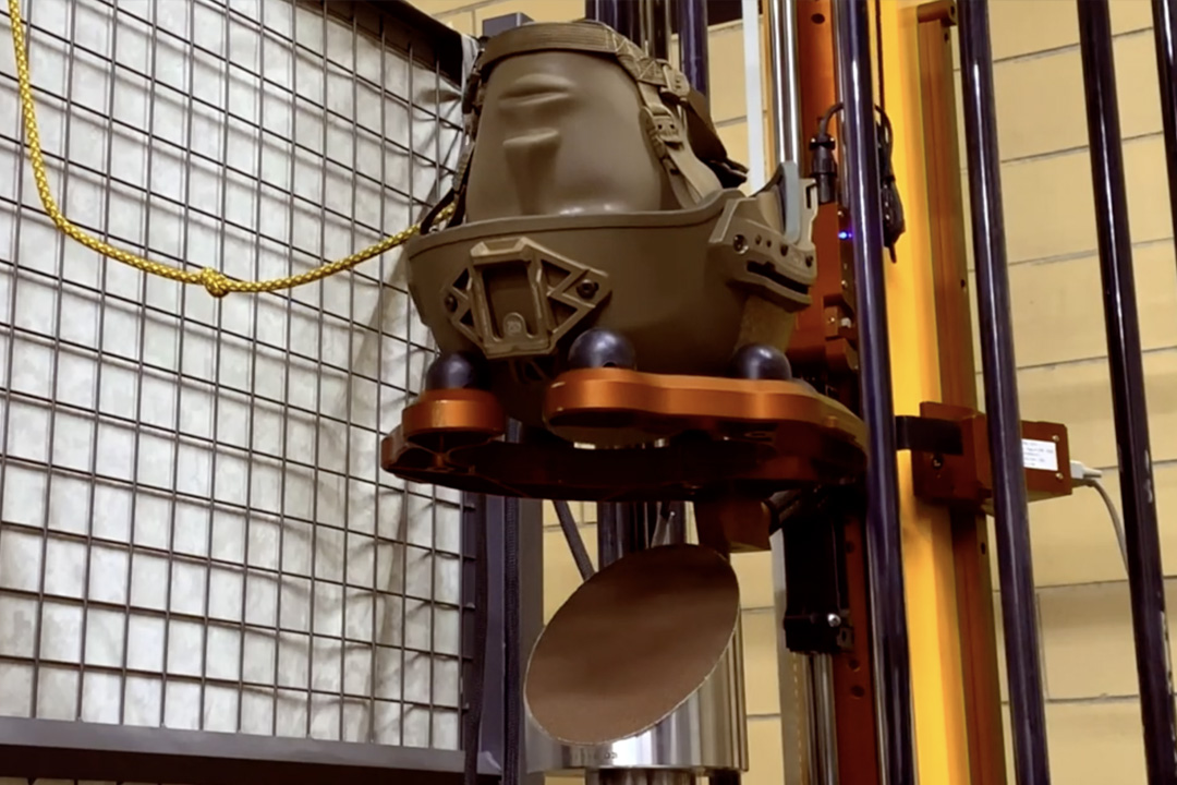Helmet on dummy head attached to testing rig