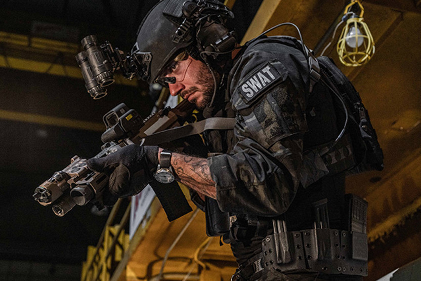 Man wearing black camo and helmet holding a gun