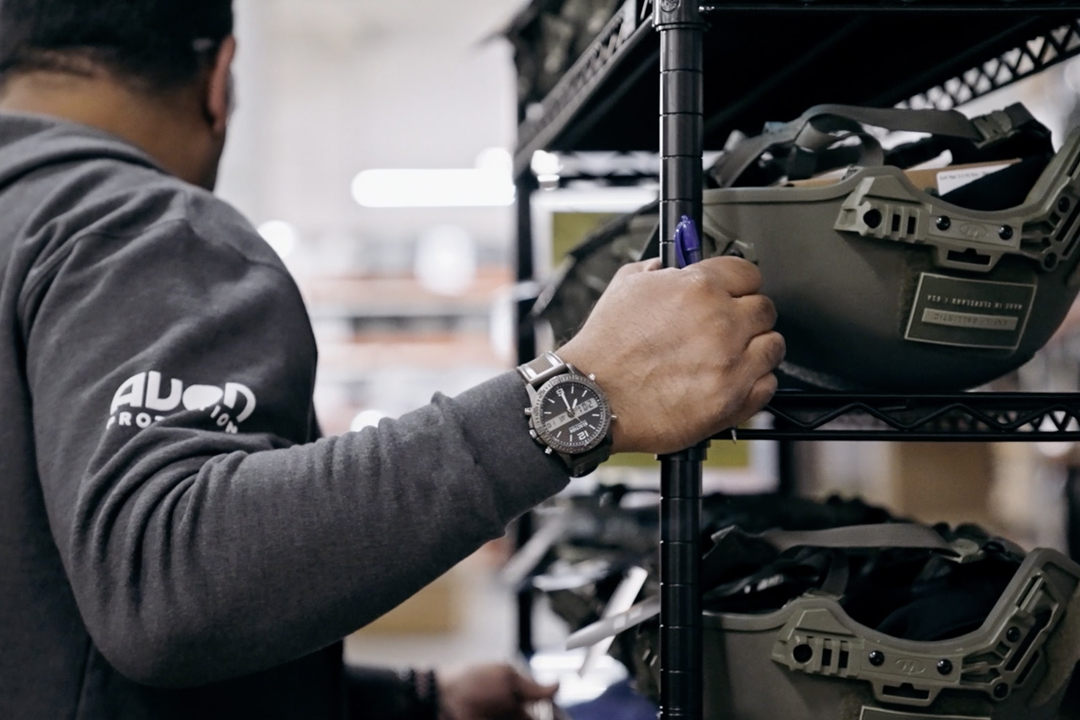 Man holding onto shelf filled with helmets