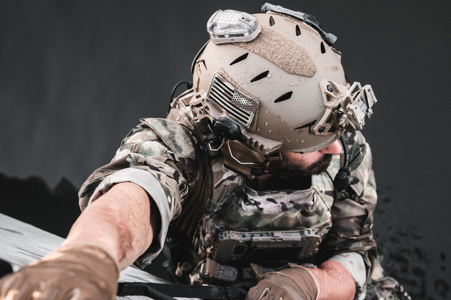 Man in helmet and camo climbing