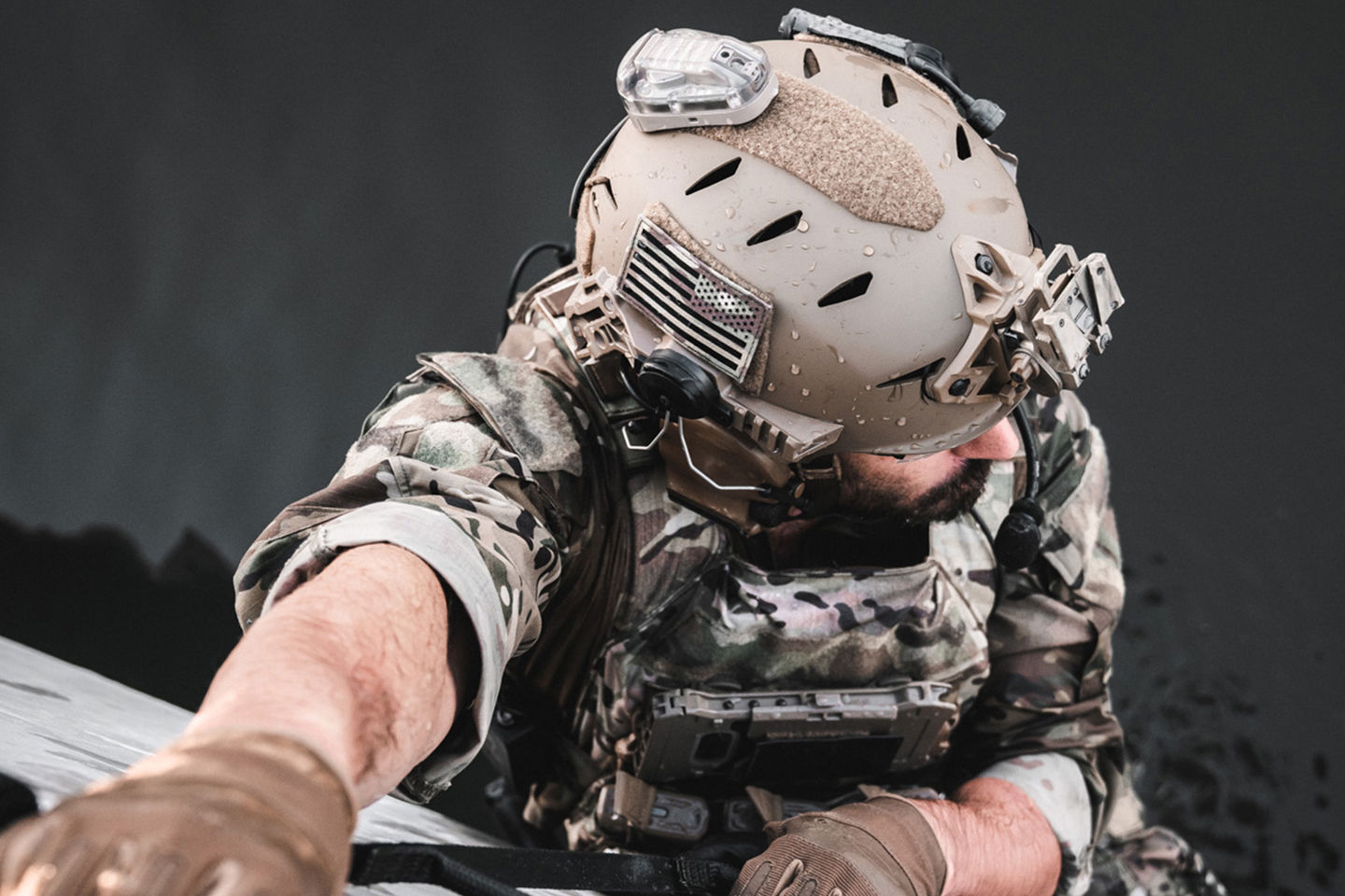 Uomo con casco e mimetica che si arrampica