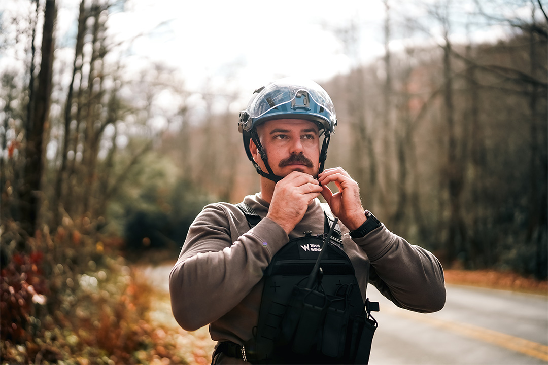 Man clipping helmet onto head