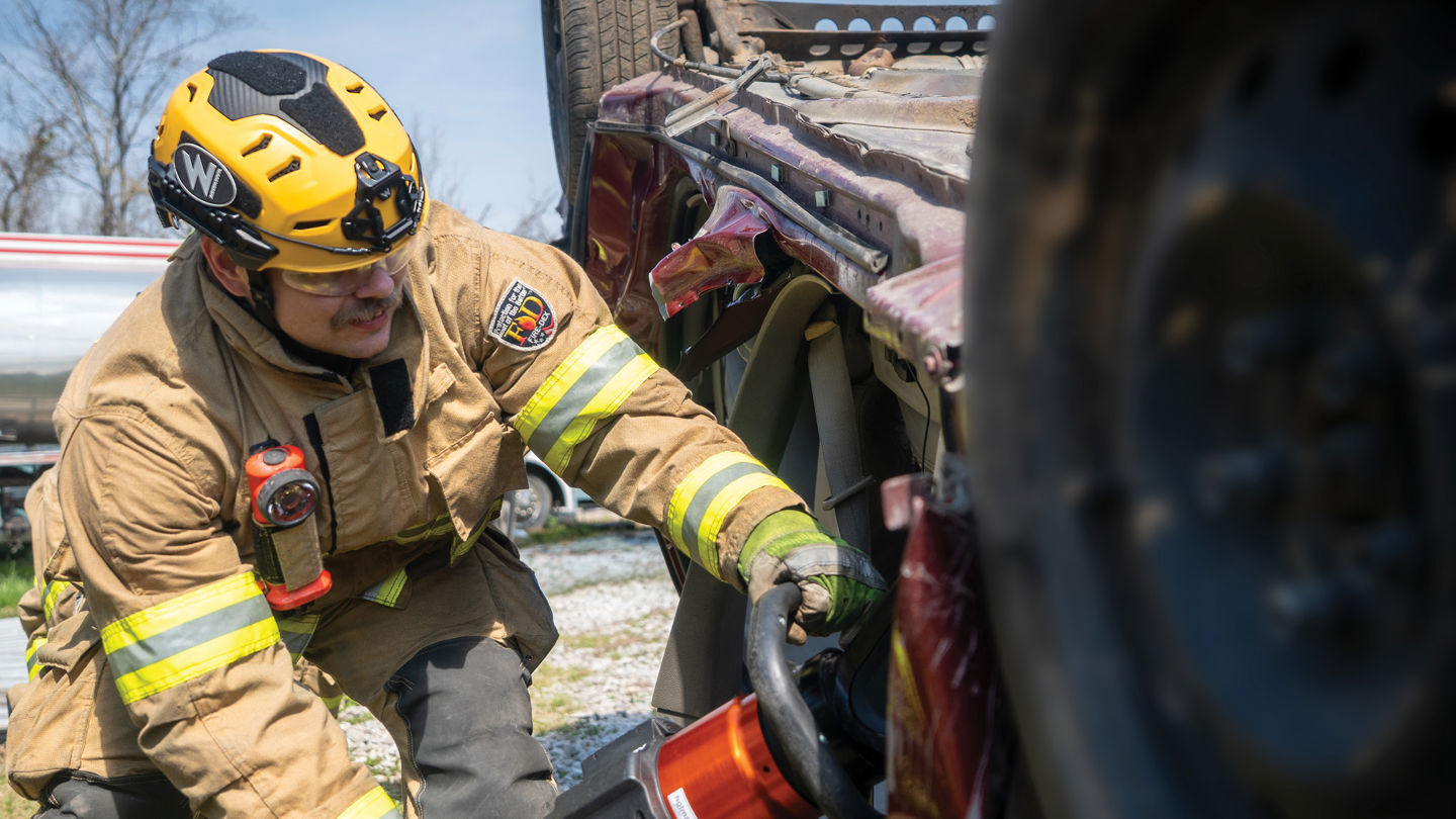 A firefighter wearing a Team Wendy RECON Tactical helmet during a vehicle extrication