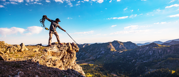 Man on cliff using rope