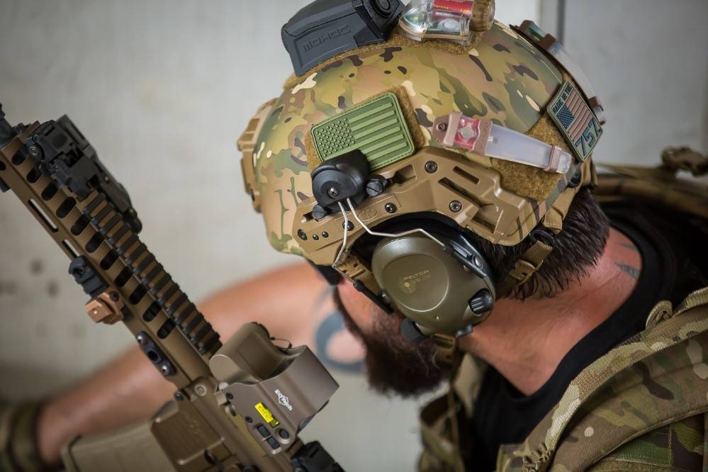 Man wearing helmet with peltor adapters on