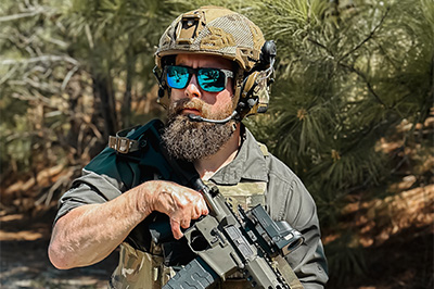 Man in helmet wearing sunglasses and holding a gun