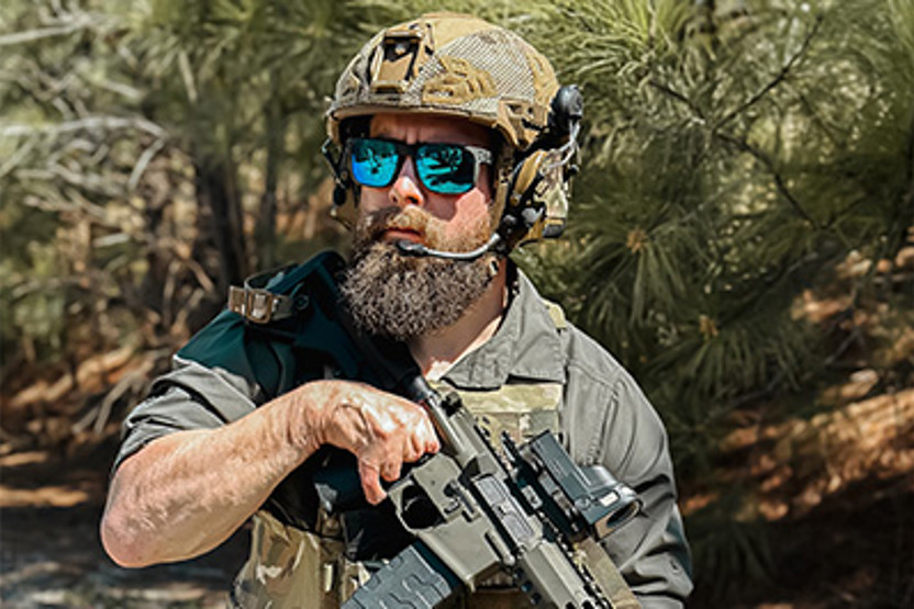 Man in helmet wearing sunglasses and holding a gun
