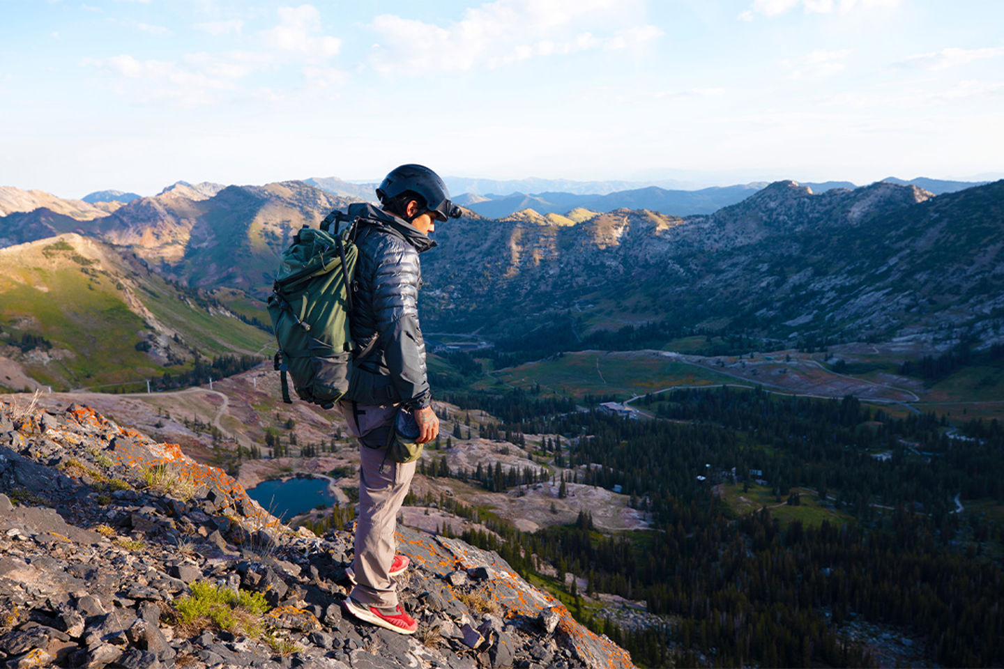 Un homme portant un casque qui contemple une chaîne de montagnes