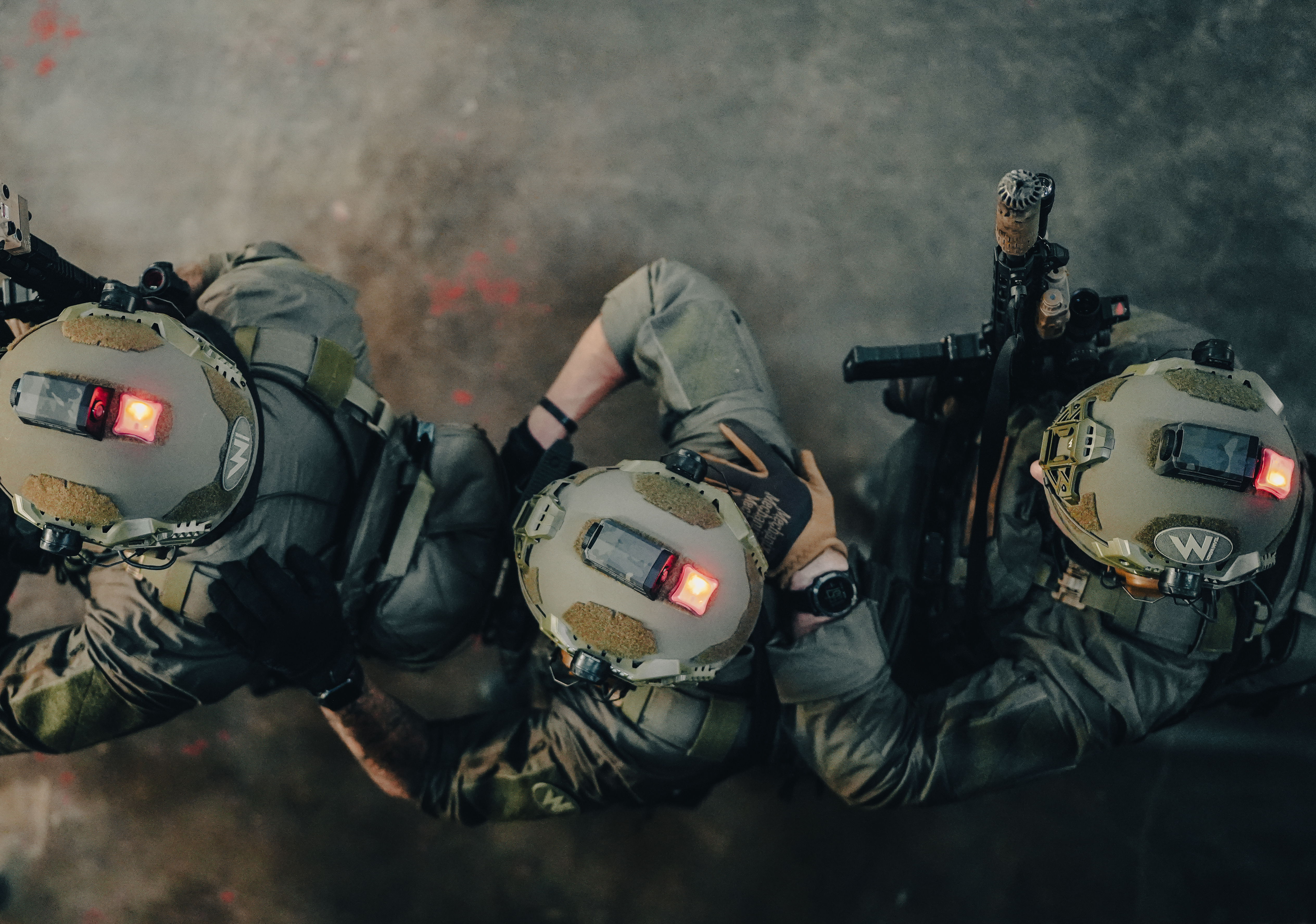 Aerial of three people in helmets in dusty environment