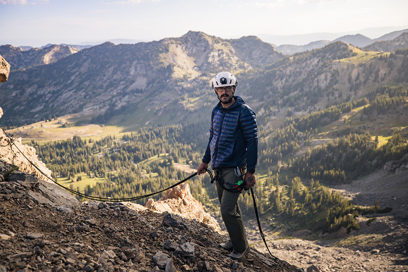 Man in white helmet holding onto a rope