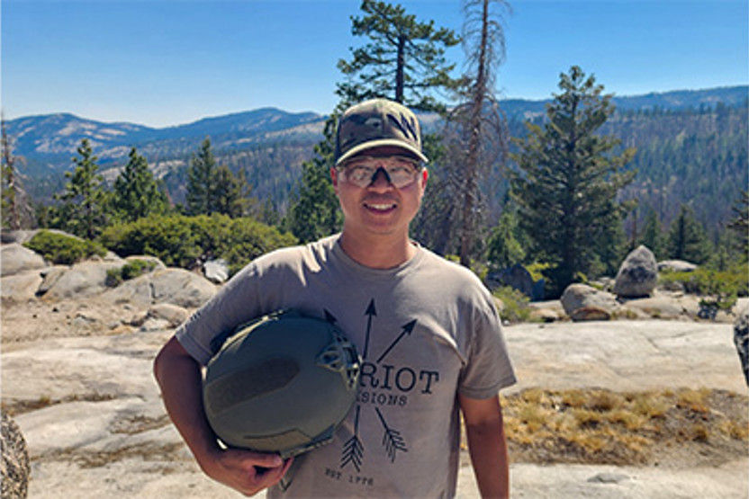 Man in safety goggles holding a helmet