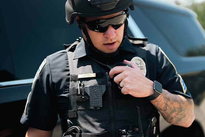 Policeman in helmet and sunglasses talking into radio