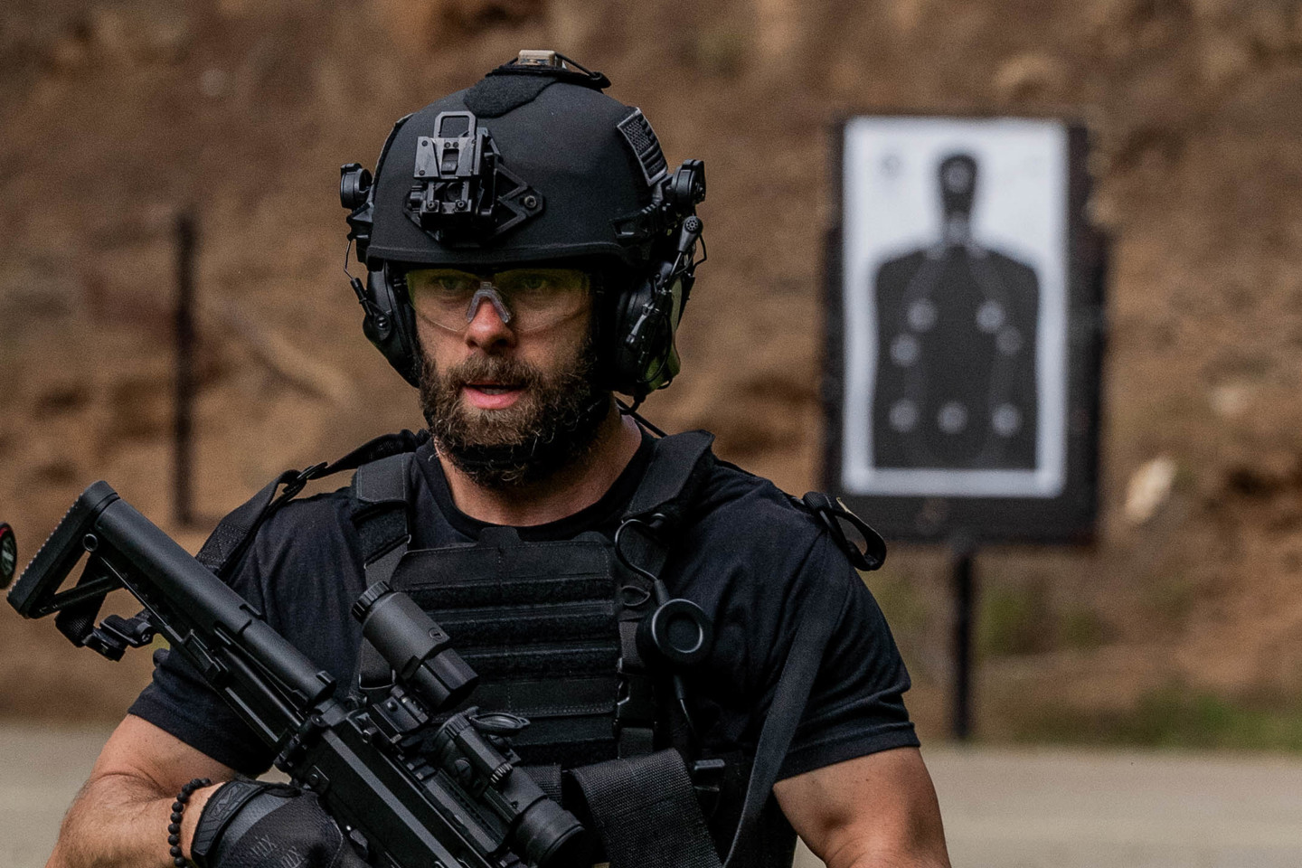 Man wearing a black helmet holding onto gun