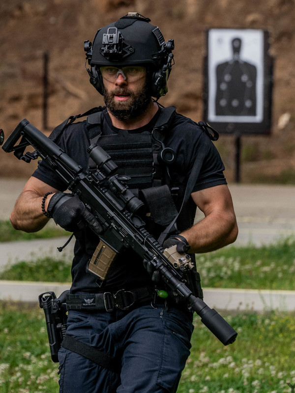 Man wearing a black helmet holding onto gun