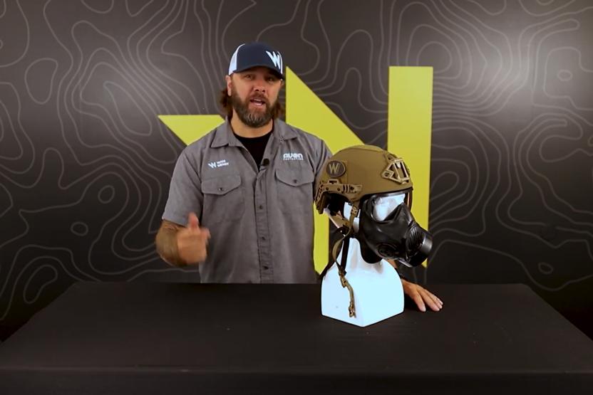 Team Wendy employee standing in front of a bust wearing a Team Wendy EXFIL ballistic helmet and an Avon Protection C50 Respirator