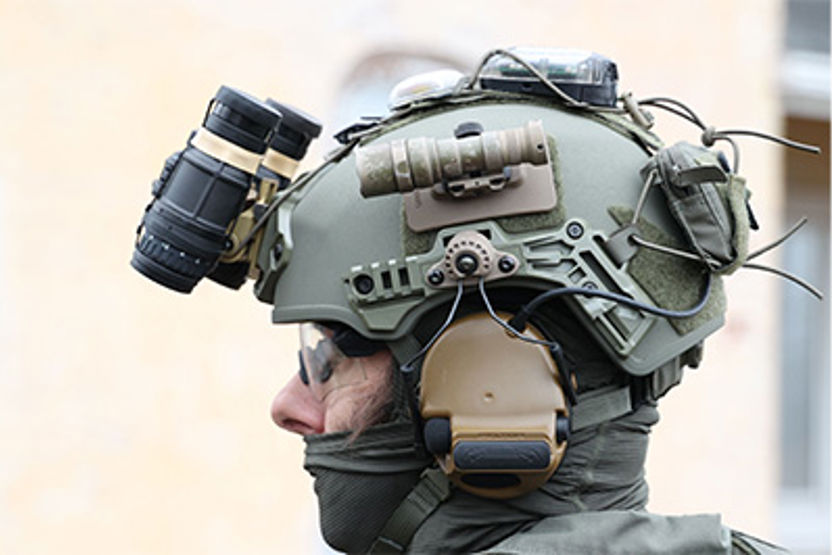 Man with green helmet on and helmet accessories