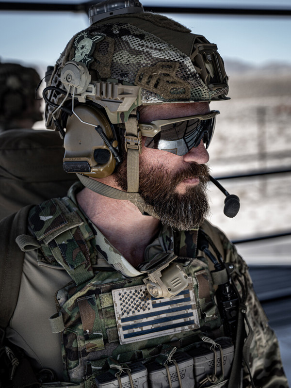 Man in green camo wearing helmet and sunglasses